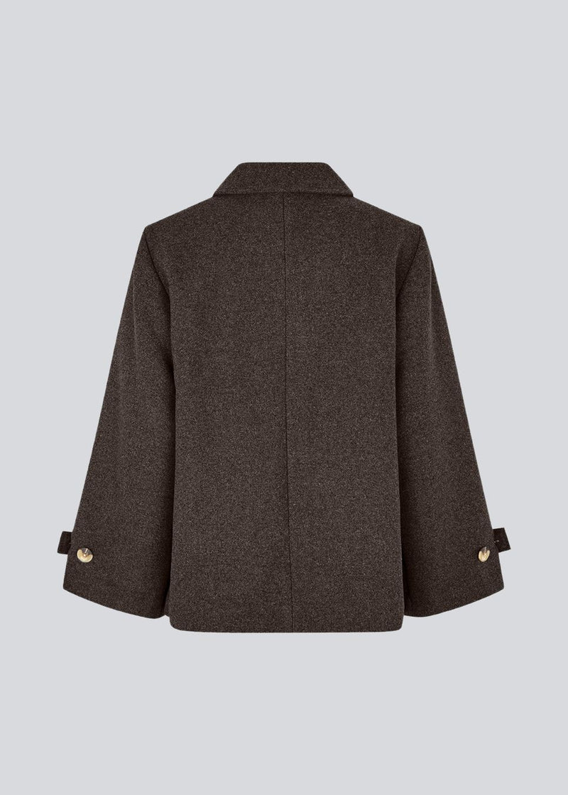 Classic short jacket in a wool mix. Ofiamd jacket has a relaxed fit, hidden button closure and collar. The model is 175 cm and wears a size s/36.