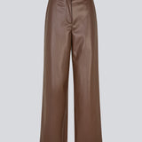 Loose trousers in 100% PU. Pellemd pants have a high waist with elastic and side pockets. The model is 175 cm and wears a size s/36.