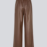 Loose trousers in 100% PU. Pellemd pants have a high waist with elastic and side pockets. The model is 175 cm and wears a size s/36.