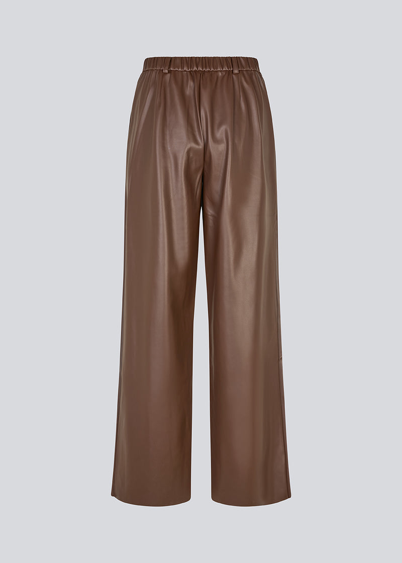 Loose trousers in 100% PU. Pellemd pants have a high waist with elastic and side pockets. The model is 175 cm and wears a size s/36.