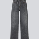Black jeans with wide legs in cotton denim. IsoldeMD pants has a high waist, front and back pockets, and a tie band at the waist. The model is 175 cm and wears a size S/36.