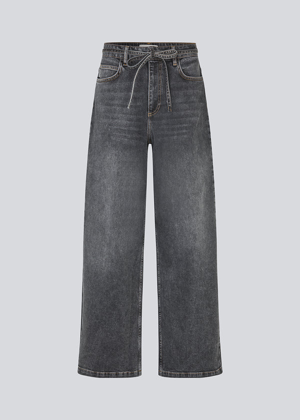 Black jeans with wide legs in cotton denim. IsoldeMD pants has a high waist, front and back pockets, and a tie band at the waist. The model is 175 cm and wears a size S/36.