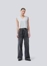 Black jeans with wide legs in cotton denim. IsoldeMD pants has a high waist, front and back pockets, and a tie band at the waist. The model is 175 cm and wears a size S/36.
