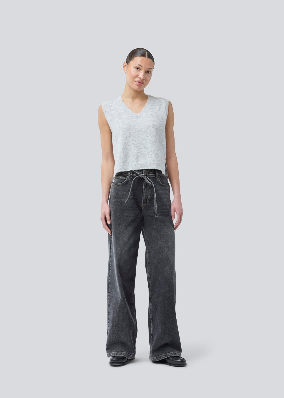 Black jeans with wide legs in cotton denim. IsoldeMD pants has a high waist, front and back pockets, and a tie band at the waist. The model is 175 cm and wears a size S/36.