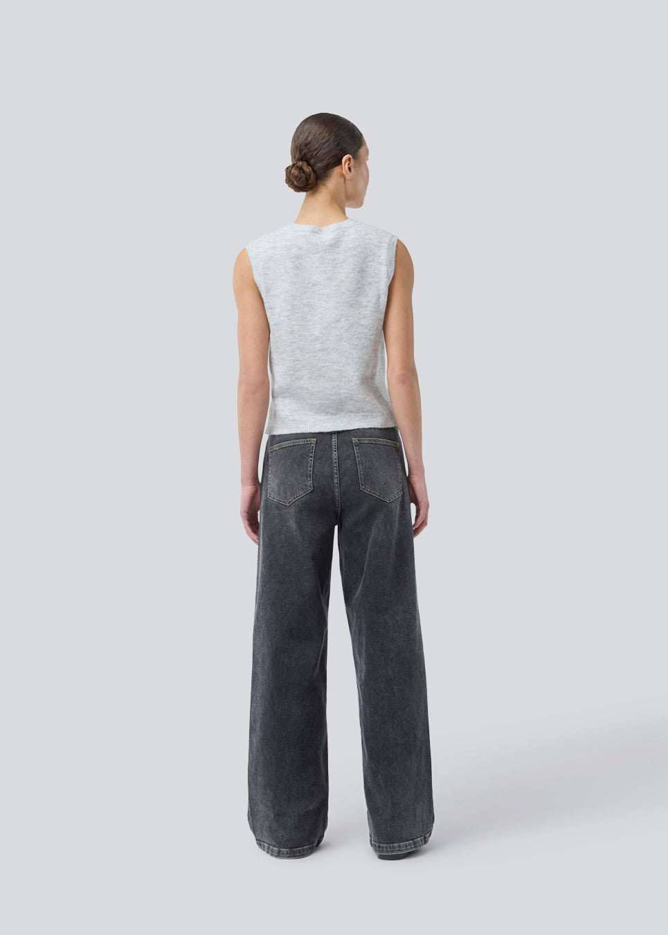 Black jeans with wide legs in cotton denim. IsoldeMD pants has a high waist, front and back pockets, and a tie band at the waist. The model is 175 cm and wears a size S/36.