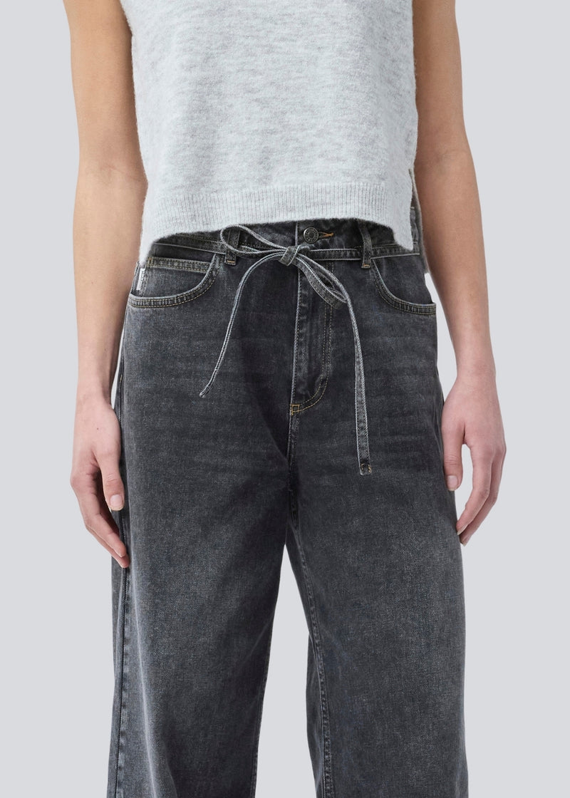 Black jeans with wide legs in cotton denim. IsoldeMD pants has a high waist, front and back pockets, and a tie band at the waist. The model is 175 cm and wears a size S/36.