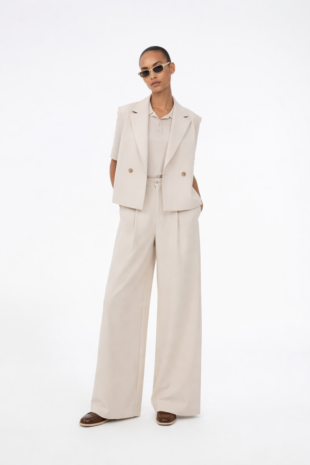 Suit pants in creme with pleats in classic gale material. Galemd wide pants has wide legs and side pockets. The model is 175 cm and wears a size S/36.

Material:
5% Elastane
76% Recycled Polyester
19% Rayon

Lining:
35% Polyester
65% Rayon