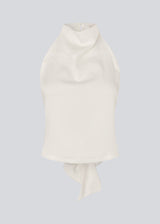 Halternecktop with a tiedetail in satin. Timmiemd top has an open back and a button closure at the neck. The model is 175 cm and wears a size s/36.