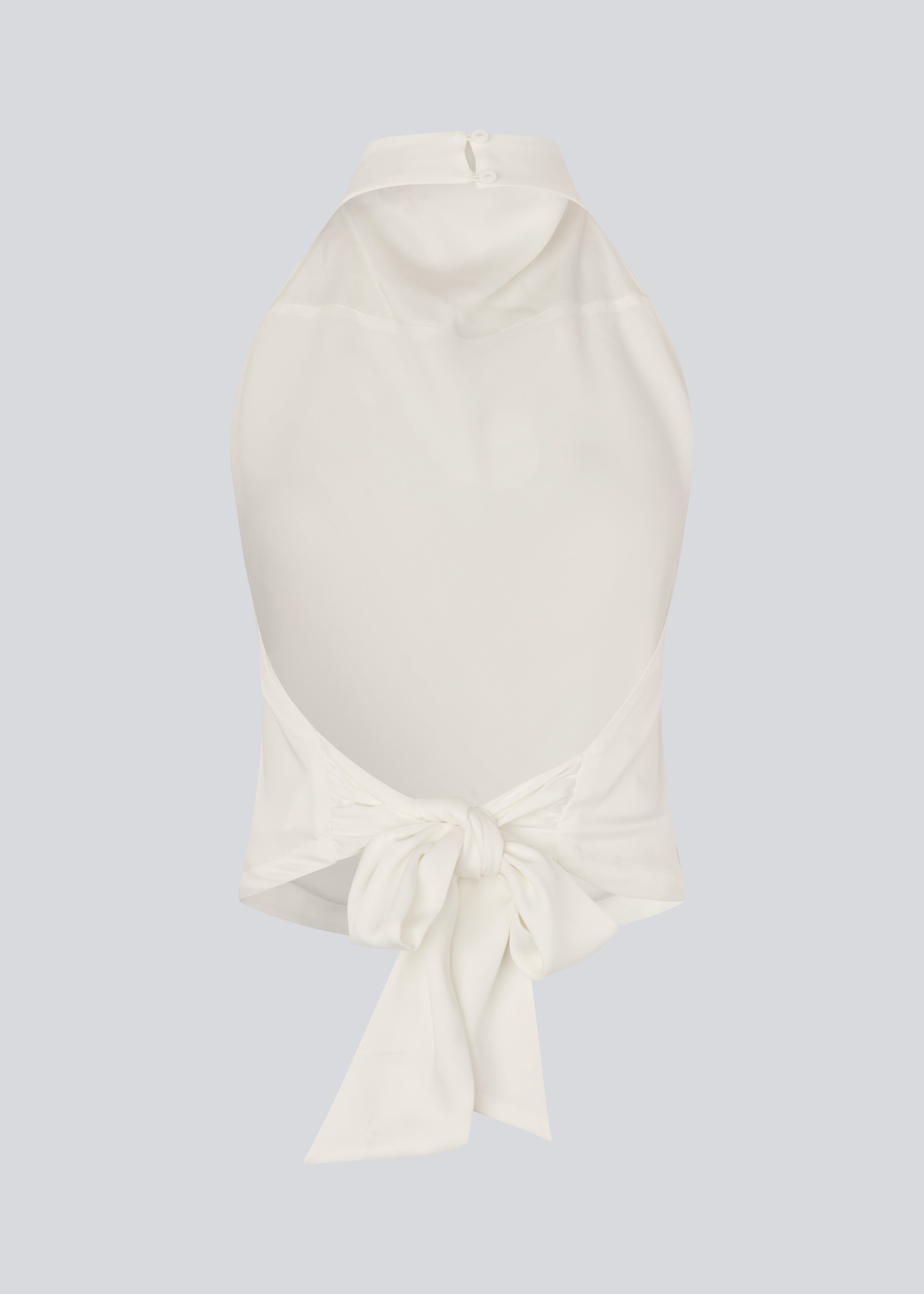 Halternecktop with a tiedetail in satin. Timmiemd top has an open back and a button closure at the neck. The model is 175 cm and wears a size s/36.