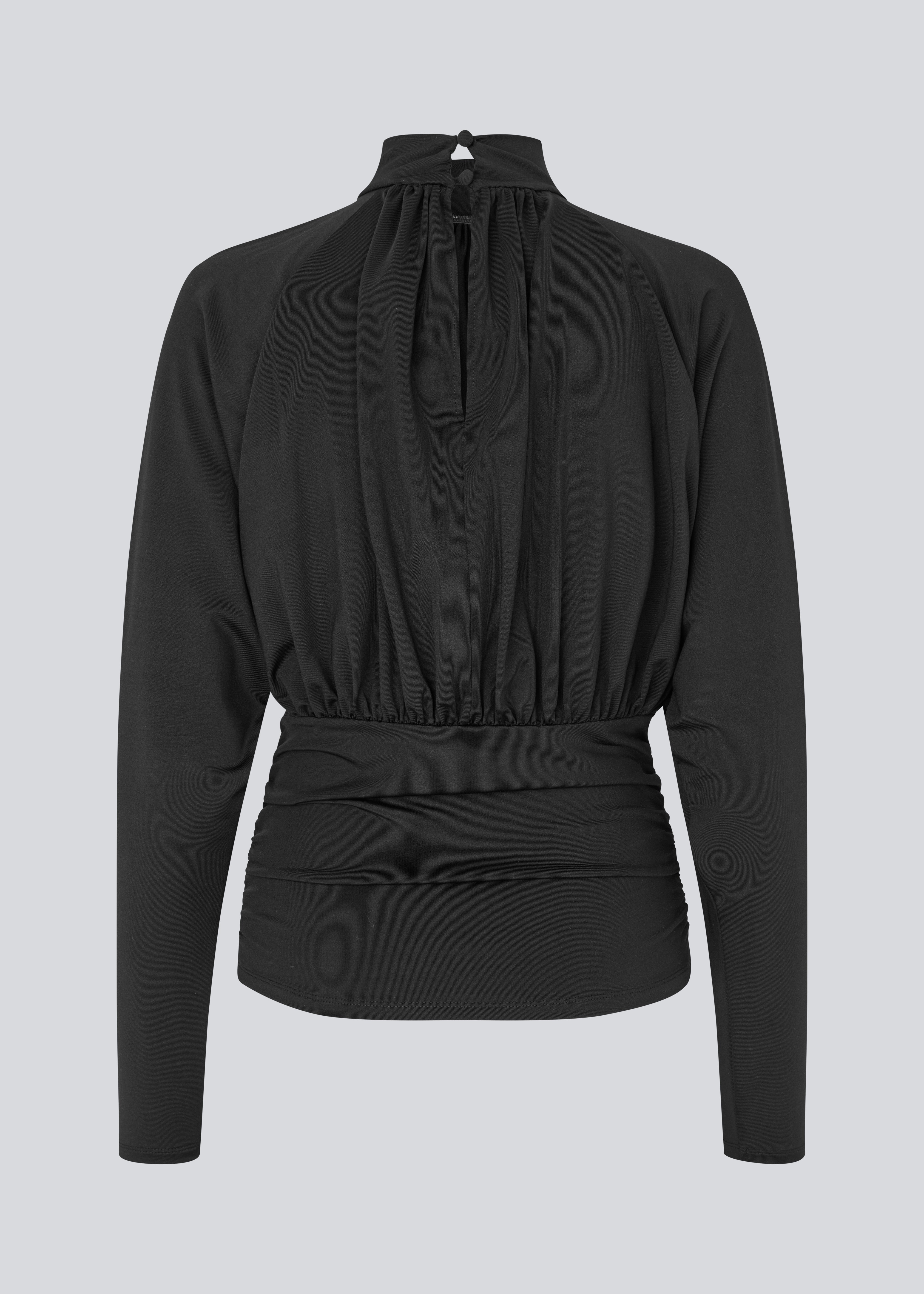 Elegant black blouse featuring a high neckline and long sleeves. Designed with delicate gathered details at the bust and waist to create a flattering silhouette. A subtle button closure at the back of the neck adds a refined and feminine touch. The stretchy fabric ensures a comfortable fit, while the draped design offers timeless elegance. Perfect for both everyday wear and special occasions.