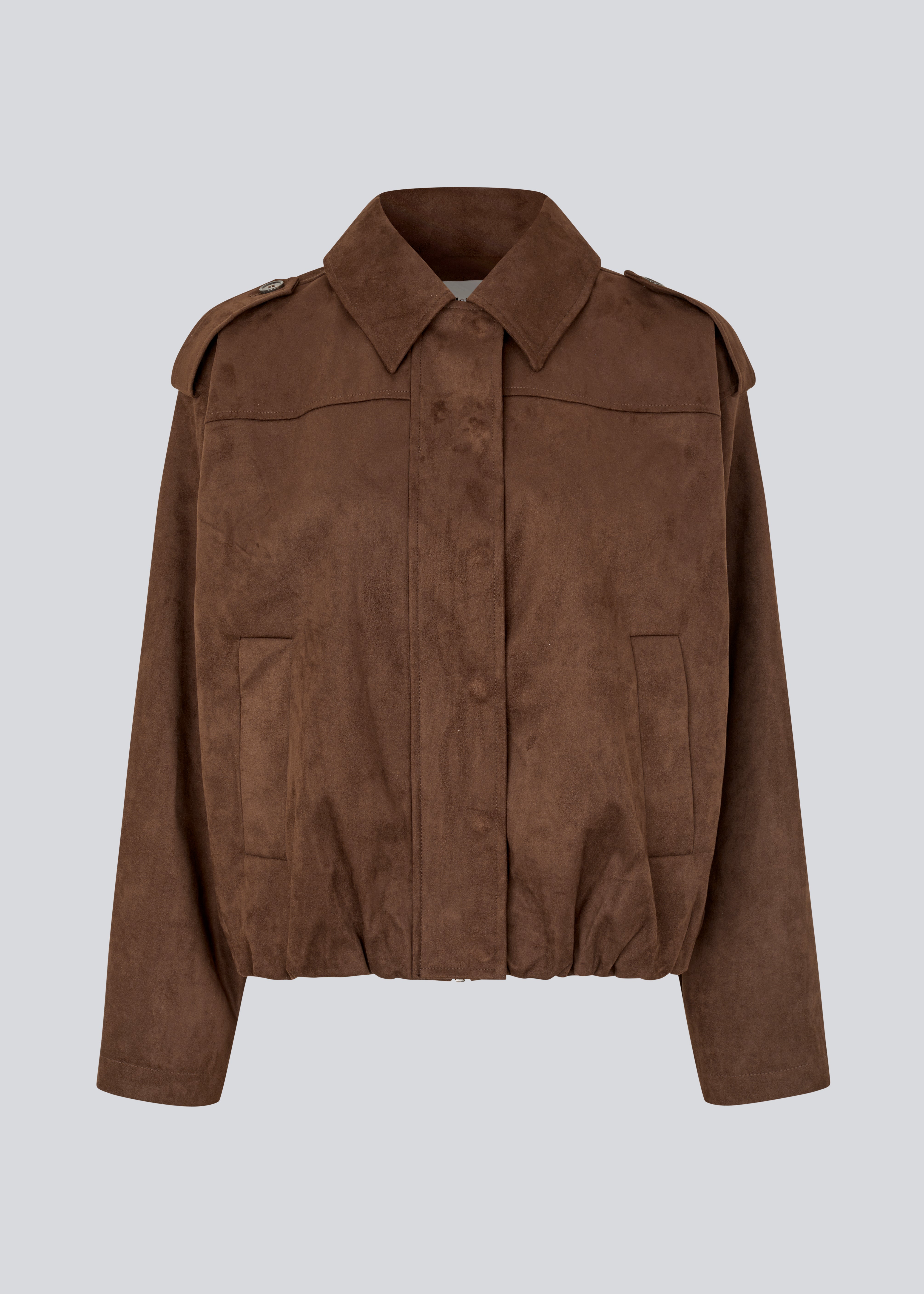 Short brown jacket made from a soft, suede-like material. Features a classic shirt collar, hidden zip and button closure at the front, and practical front pockets. The structured shoulders with strap details and the slightly elasticated hem add a modern, tailored touch. A versatile and stylish piece, perfect for transitional weather and everyday wear.