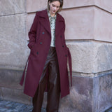Classic, double-breasted wool coat with collar and notch lapels. ShayMD coat has a wide tiebelt at waist, shoulder straps, wide cuffs and open yoke. With lining and single back vent.