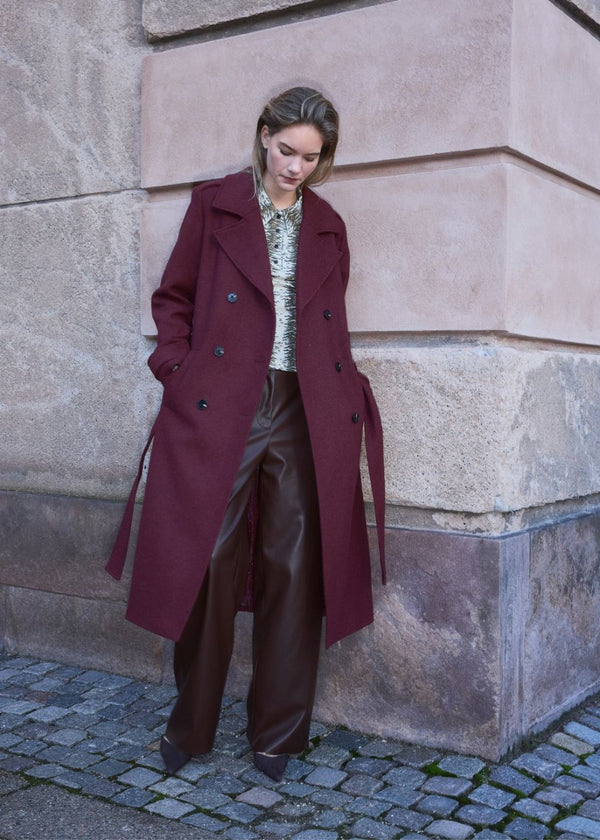 Classic, double-breasted wool coat with collar and notch lapels. ShayMD coat has a wide tiebelt at waist, shoulder straps, wide cuffs and open yoke. With lining and single back vent.