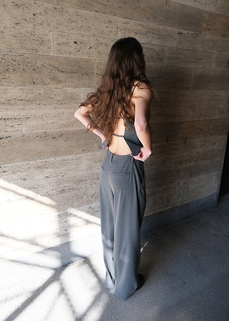 Grey suit pants with pleats and wide legs. Tuesdaymd pants have a medium-highwaist, zipper, side pockets and paspoil pockets in the back. The model is 175 cm and wears a size s/36.