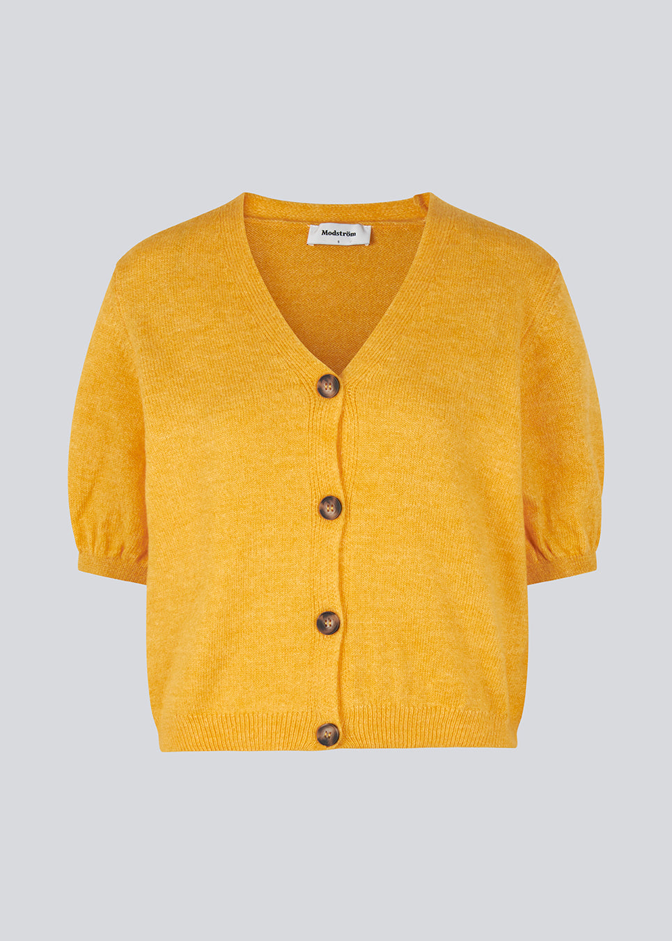 Trendy cardigan in yellow with short puffy sleeves and button closure at the front. Irene cardigan comes in a soft material perfect for the early spring days. The model is 174 cm and wears a size S/36