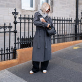 Classic, double-breasted wool coat in grey with collar and notch lapels. ShayMD coat has a wide tiebelt at waist, shoulder straps, wide cuffs and open yoke. With lining and single back vent.