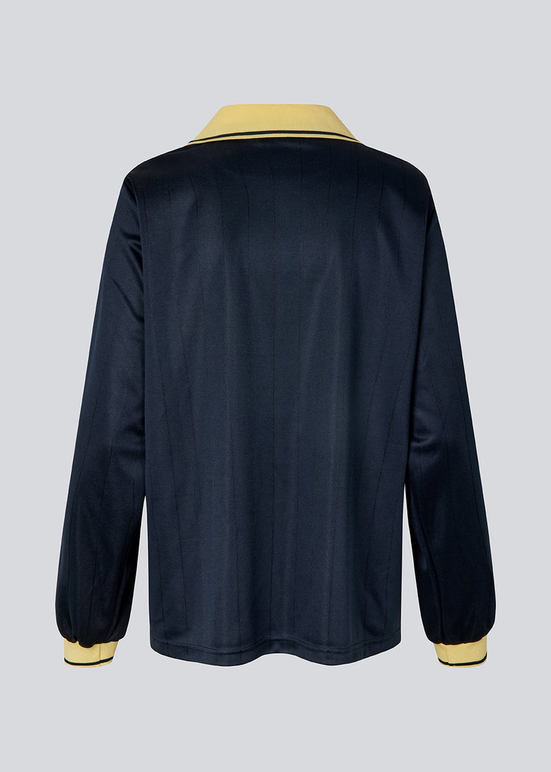 Football jersey made in collaboration with the Danish football team Brøndby Women. The 1971 Polo in navy with yellow details features a loose fit, with a placket closure and collar, as well as long sleeves that have ribbed cuffs. The polo features Brøndby Women and Modström logos on the chest.