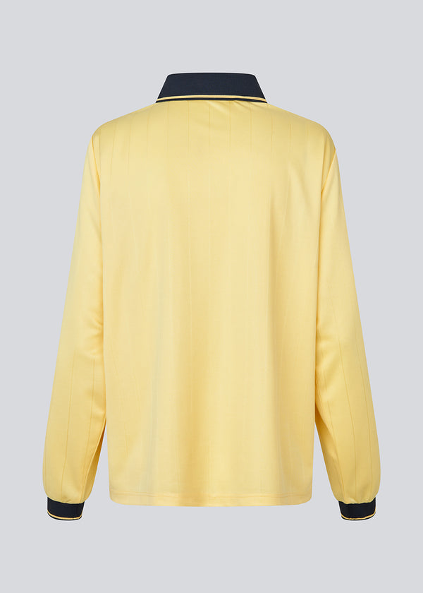 Football polo in yellow with navy blue details made in collaboration with Brøndby IF's women's team. The 1971 Polo has a loose fit with a placket closure and collar, as well as long sleeves with ribbed cuffs. The polo features the Brøndby IF Women and Modström logos on the chest.