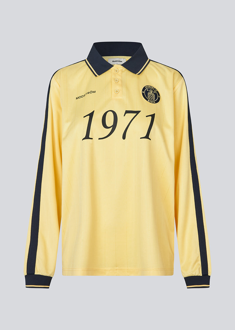 Football polo in yellow with navy blue details made in collaboration with Brøndby IF's women's team. The 1971 Polo has a loose fit with a placket closure and collar, as well as long sleeves with ribbed cuffs. The polo features the Brøndby IF Women and Modström logos on the chest.