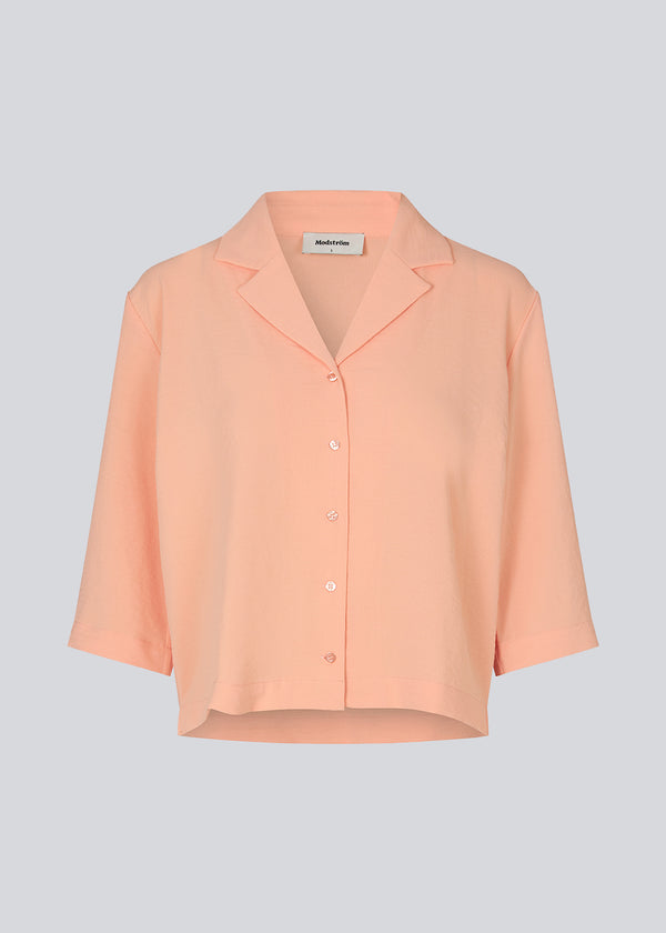 Shirt in the color Peach Necrar in a relaxed silhouette and 3/4 length sleeves. AaliyahMD shirt has a resort collar, dropped shoulders and button closure in front.