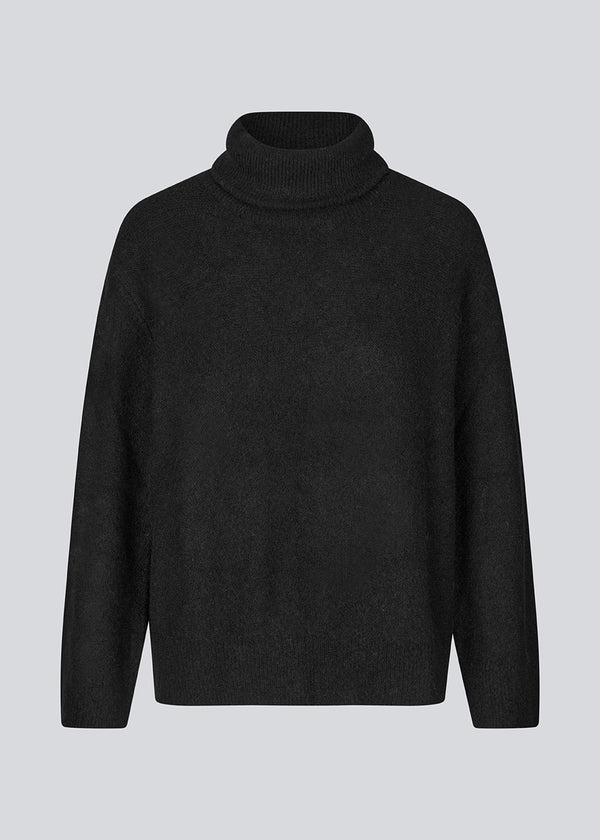 Black knitted jumper in wool and llama wool mix. AdrianMD t-neck has a relaxed fit with dropped shoulder, rib-knitted rollneck and trimmings.