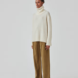 Oversized knitted jumper in white in wool and llama wool mix. AdrianMD t-neck has a relaxed fit with dropped shoulder, rib-knitted rollneck and trimmings. The model is 177 cm and wears a size S/36.