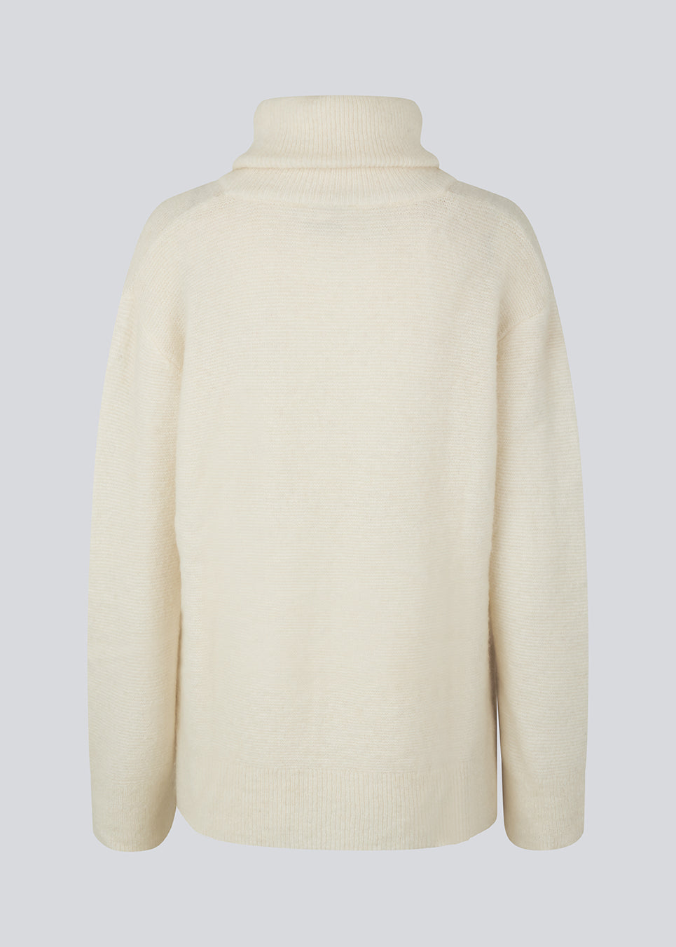 Oversized knitted jumper in white in wool and llama wool mix. AdrianMD t-neck has a relaxed fit with dropped shoulder, rib-knitted rollneck and trimmings. The model is 177 cm and wears a size S/36.