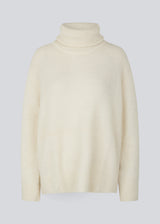 Oversized knitted jumper in white in wool and llama wool mix. AdrianMD t-neck has a relaxed fit with dropped shoulder, rib-knitted rollneck and trimmings. The model is 177 cm and wears a size S/36.