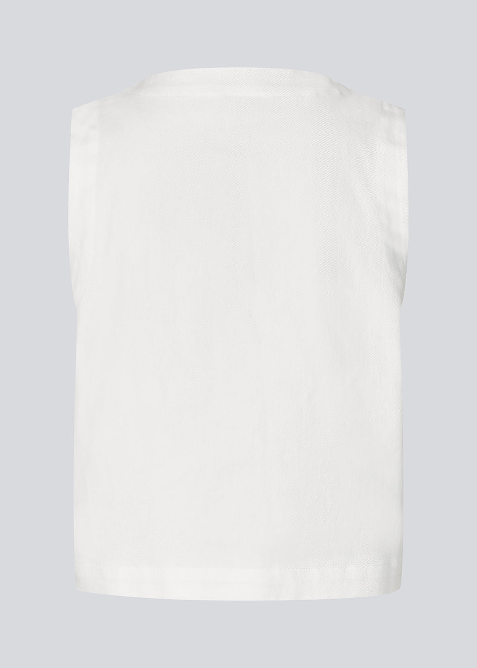 Sleeveless denim top with silver buttons. The AggiMD Solid Top has a relaxed fit with a round neckline. A modern and casual top that combines classic denim with stylish details.