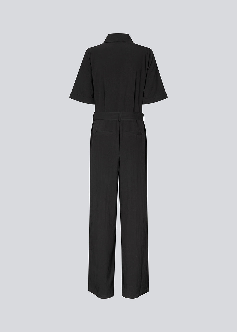 Shirt-inspired jumpsuit with a waist belt. The AgneteMD Jumpsuit features details such as a collar, button closure, short wide sleeves, straight legs, and pressed creases. A modern choice that combines comfort with style.