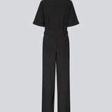 Shirt-inspired jumpsuit with a waist belt. The AgneteMD Jumpsuit features details such as a collar, button closure, short wide sleeves, straight legs, and pressed creases. A modern choice that combines comfort with style.