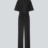 Shirt-inspired jumpsuit with a waist belt. The AgneteMD Jumpsuit features details such as a collar, button closure, short wide sleeves, straight legs, and pressed creases. A modern choice that combines comfort with style.