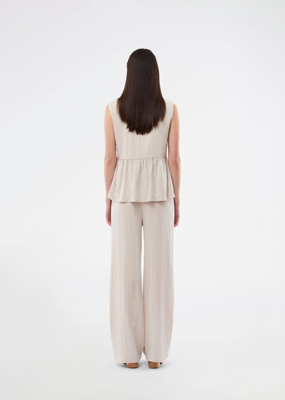 Feminine vest top with a gathered, loose hem. The AgneteMD Vest is sleeveless with a V-neckline and a simple button closure. Can be styled alone or layered for a modern and versatile look.