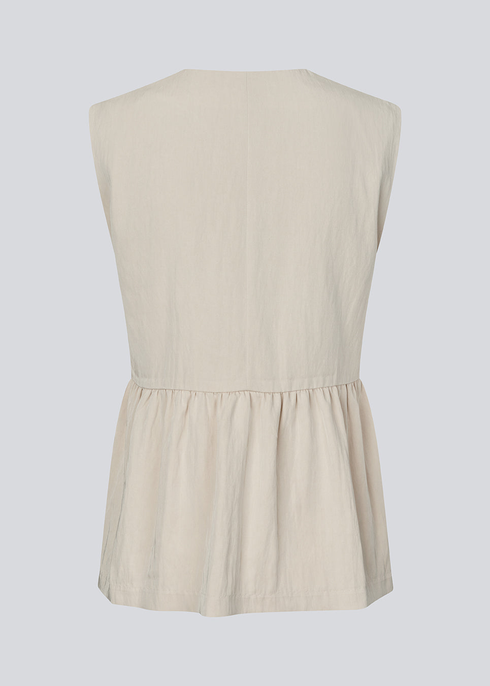 Feminine vest top with a gathered, loose hem. The AgneteMD Vest is sleeveless with a V-neckline and a simple button closure. Can be styled alone or layered for a modern and versatile look.
