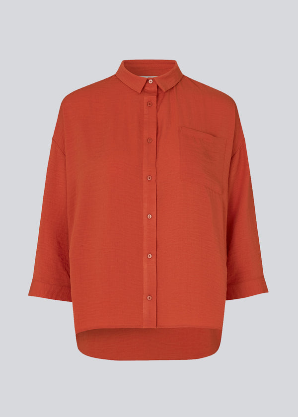 Beautiful red shirt in a classic design. Alexis shirt has a collar and is closed at front by buttons. The shirt has 3/4 length sleeves and a chest pocket, which adds details. The model is 174 cm and wears a size S/36  Material: 100% Polyester