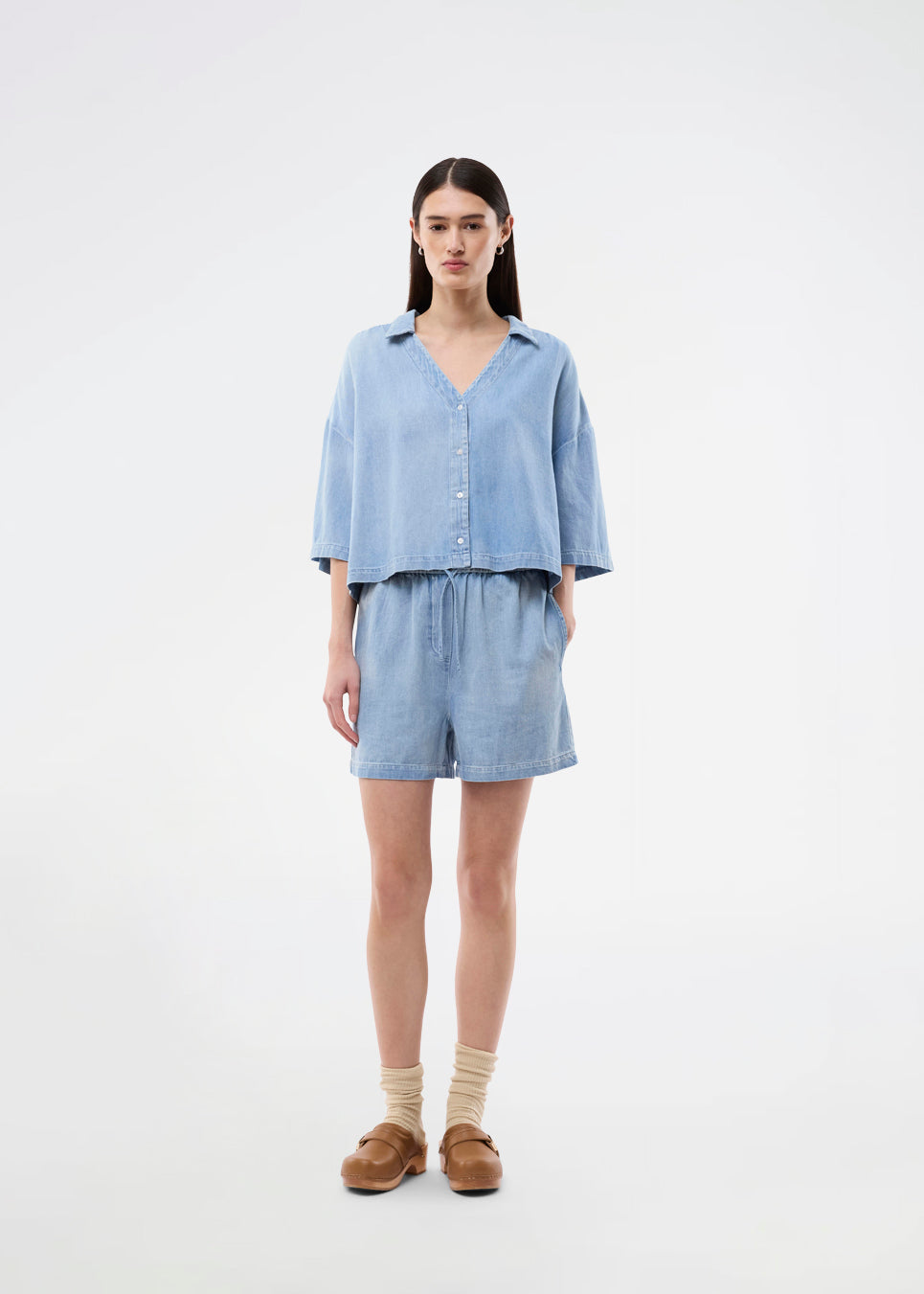 Light short-sleeve shirt in cotton denim. The AlvarMD Shirt is short and relaxed with a collar, V-neckline, and button closure. A casual and modern shirt, perfect for both everyday wear and light summer looks.