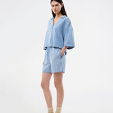 Light short-sleeve shirt in cotton denim. The AlvarMD Shirt is short and relaxed with a collar, V-neckline, and button closure. A casual and modern shirt, perfect for both everyday wear and light summer looks.