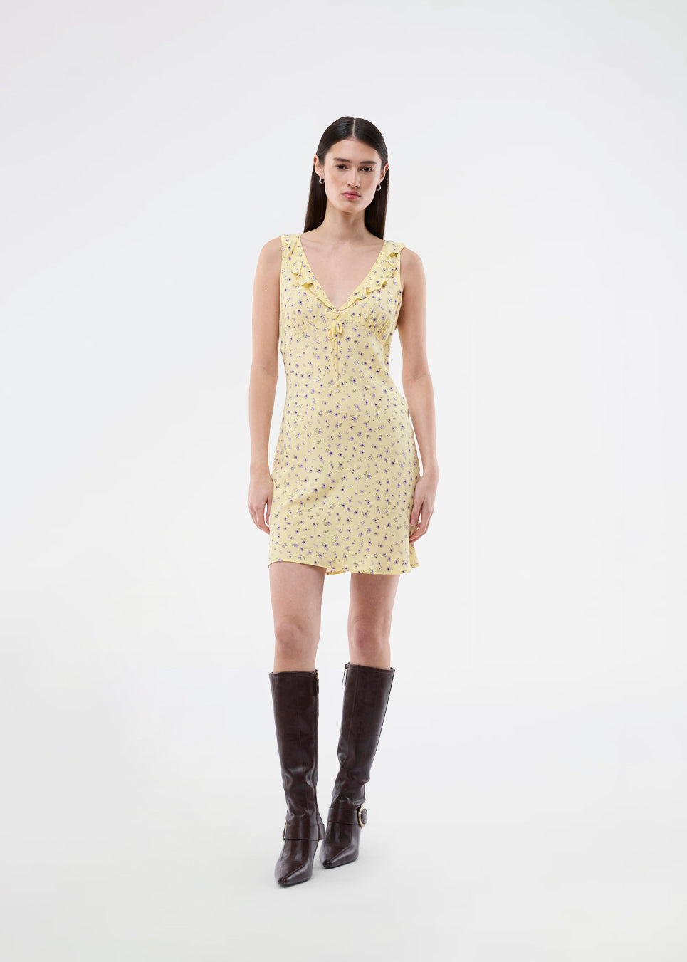 Feminine mini dress with a summery floral print. The AlyssaMD Print Dress is sleeveless and features a V-neckline with a ruffle trim and bow detail. The dress is fitted at the waist and has a beautifully flowing skirt, creating a feminine and elegant look.