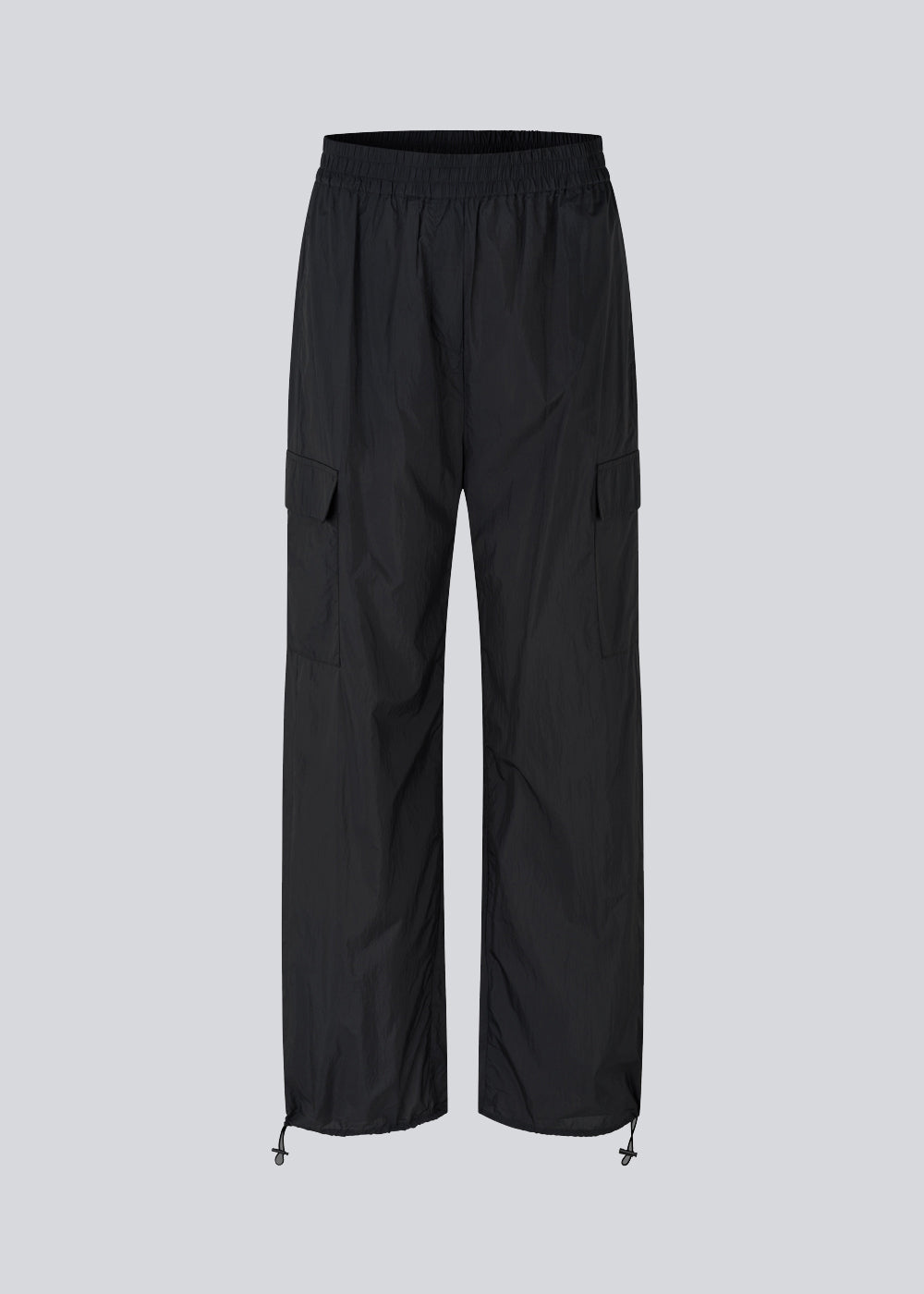 Black pants in recycled nylon. AmayaMD pants have a high waist and straight legs with adjustable drawstring at hem. Covered elasticated waist and two large pockets on the legs.