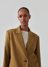 Oversized blazer with a drapy fit. AnkerMD blazer has collar and notch lapels with a single button closure. Flap welt front pockets. Slits on cuffs and single back vent. Lined.  The model is 177 cm and wears a size S/36. Style the blazer with matching pants in the same color: AnkerMD pants