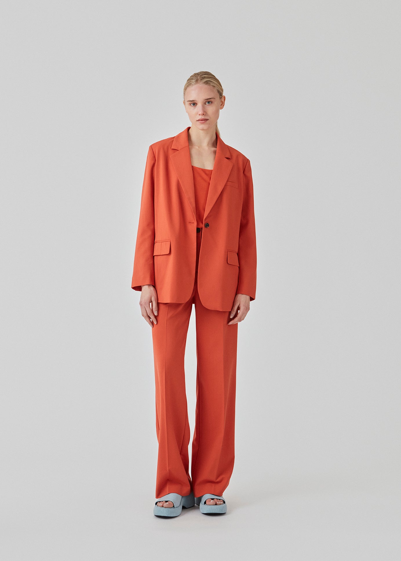 Pants in red with wide legs and a medium waist. AnkerMD pants have creases, button and zip fly, side pockets and paspel back pockets.  The model is 177 cm and wears a size S/36. Style the pants with a matching blazer in the same color: AnkerMD blazer.