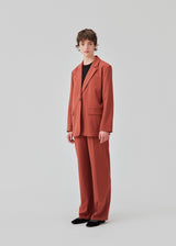 Pants in the color Maple with wide legs and a medium waist. AnkerMD pants have creases, button and zip fly, side pockets and paspel back pockets. 