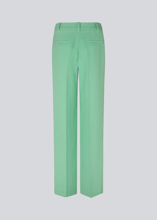 Pants in green with wide legs and a medium waist. AnkerMD pants have creases, button and zip fly, side pockets, and paspel back pockets. The model is 177 cm and wears a size S/36. Style the pants with a matching blazer in the same color: AnkerMD blazer.