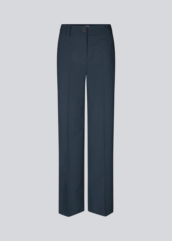 Pants in navy blue with wide legs and a medium waist. AnkerMD pants have creases, button and zip fly, side pockets, and paspel back pockets. Style the pants with a matching blazer in the same color: AnkerMD pants.