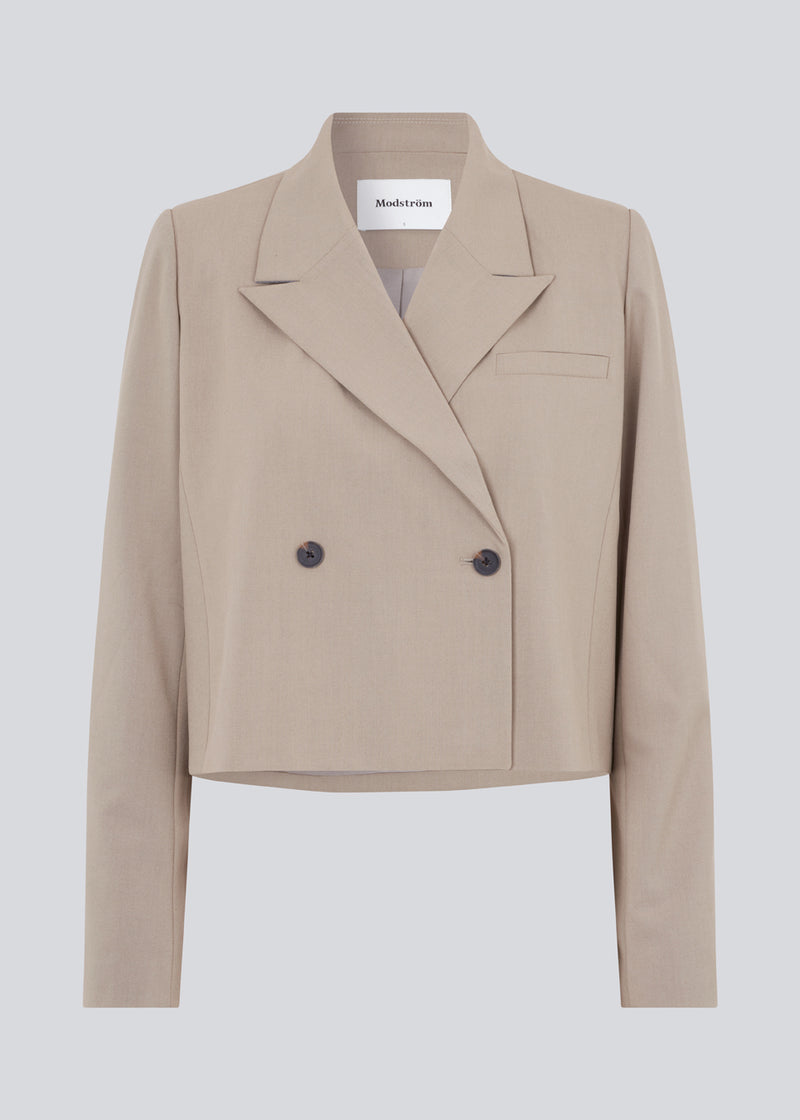 Short, double-breasted blazer in beige with collar and notch lapels. AnkerMD short blazer has a straight fit with two buttons and a decorative chest pocket.
