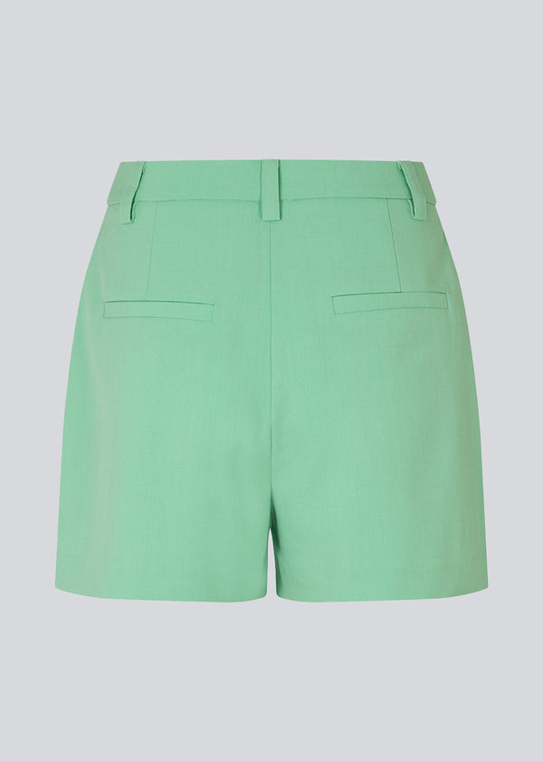Wide-legged green shorts and medium waist. AnkerMD shorts have creases down the front, zip fly and button, side pockets, and fake back pockets. Style the shorts with a matching blazer: AnkerMD blazer, in the same color.