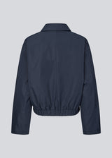 Modern and functional jacket. The Badumd jacket is designed with a classic collar, concealed fastening, and an elasticated hem that creates a relaxed, slightly cropped silhouette. A stylish transitional jacket that combines a minimalist look with comfort and versatile styling options.