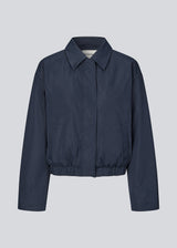 Modern and functional jacket. The Badumd jacket is designed with a classic collar, concealed fastening, and an elasticated hem that creates a relaxed, slightly cropped silhouette. A stylish transitional jacket that combines a minimalist look with comfort and versatile styling options.