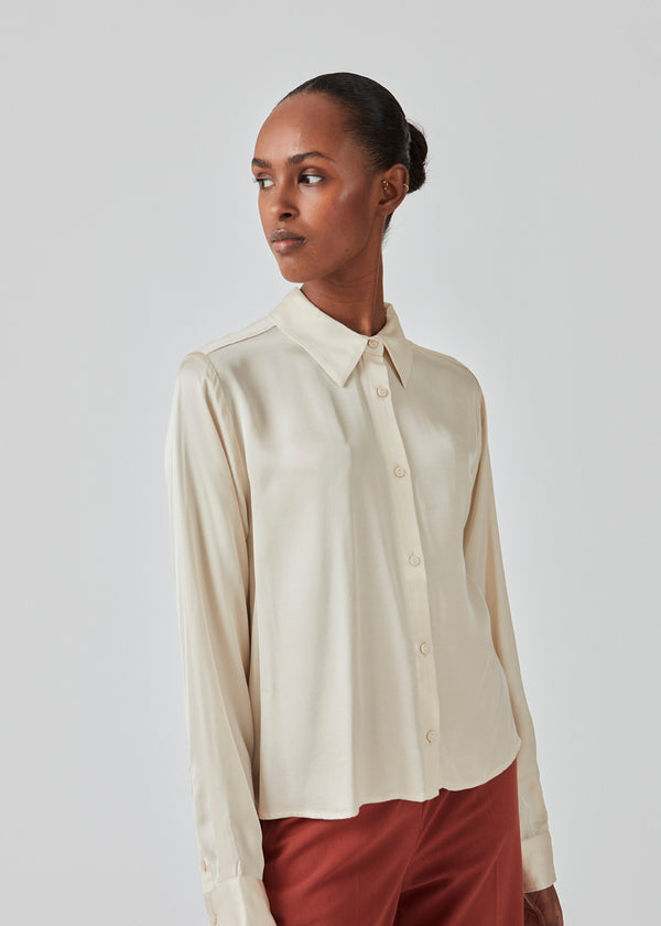 Satin shirt in summer sand with a soft drape in a more responsible quality. BeateMD shirt has a collar and buttons in front along with a double-layered yoke at the back. Relaxed fit.