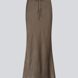 Long elegant skirt in luxurious textured satin. The BelineMD Skirt is fitted at the waist, features a subtle A-line silhouette, and a stylish belt-tie detail - a chic and versatile piece made from 100% recycled polyester.